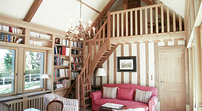 Bibliothèque avec escalier plus mezzanine en chêne dans salon de lecture / bureau.