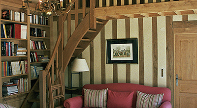 Bibliothèque avec escalier plus mezzanine en chêne dans salon de lecture / bureau.