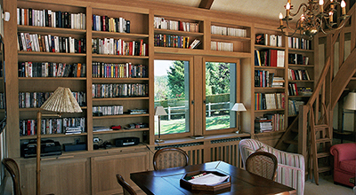 Bibliothèque avec escalier plus mezzanine en chêne dans salon de lecture / bureau.